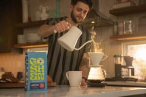 Barista pouring hot water into a coffee dripper with steam rising, as part of Drive Social Media's local advertising and local marketing campaign.