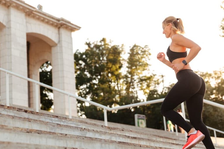 A girl wearing red running shoes climbs the stairs and runs.