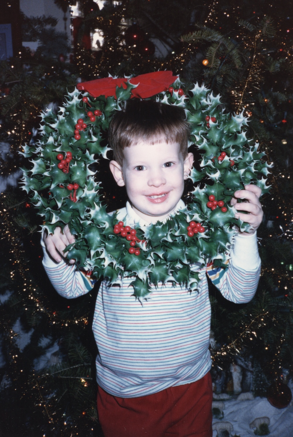 Child holding Christmas wreath evoking nostalgic holiday memories